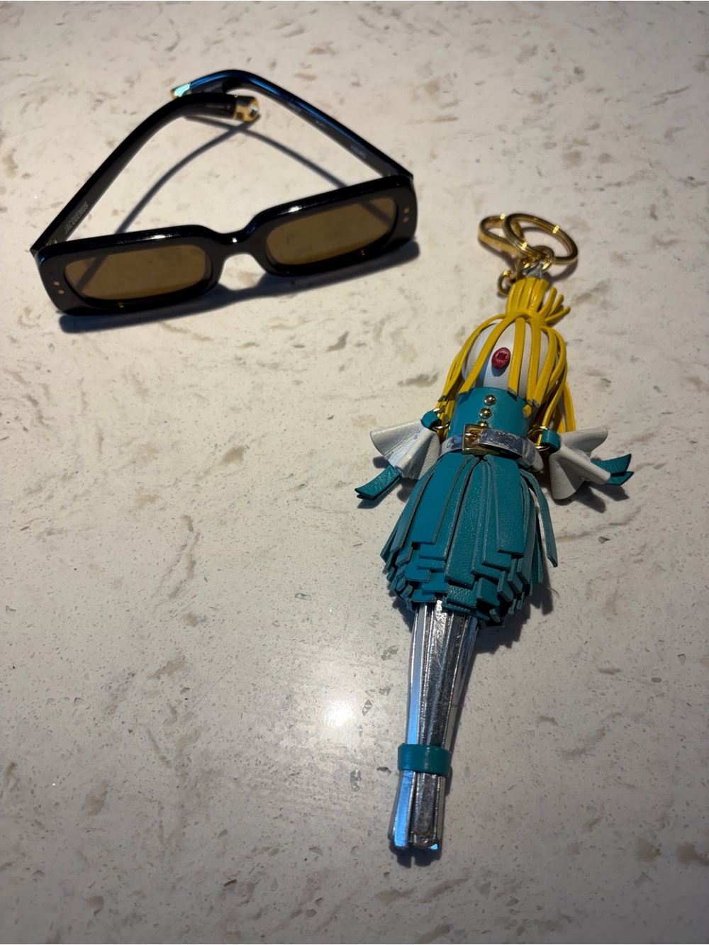 Prada Teal, Yellow & Silver Leather Tassel Keychain and Jacquemus sunglasses